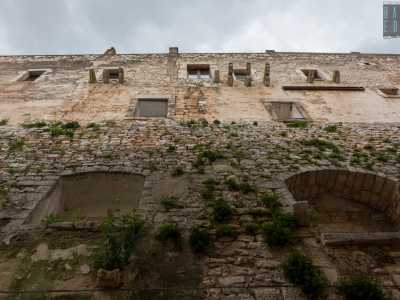 ...funge da base del sovrastante edificio contraddistinto da finestroni e mensoloni litici